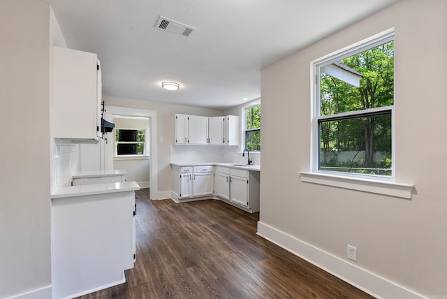 4300 W 16th St, Little Rock, AR 72204 - kitchen with light countertops, white cabinetry, a sink, and baseboards