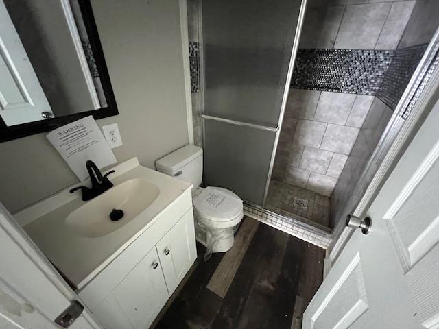 613 Paschal, Trumann, AR 72472 - bathroom featuring a shower stall, toilet, vanity, and wood finished floors