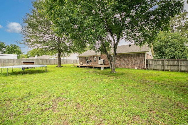 view of yard featuring a trampoline and a wooden deck
