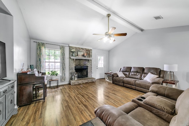 living area featuring wood finished floors, plenty of natural light, ceiling fan, and a fireplace