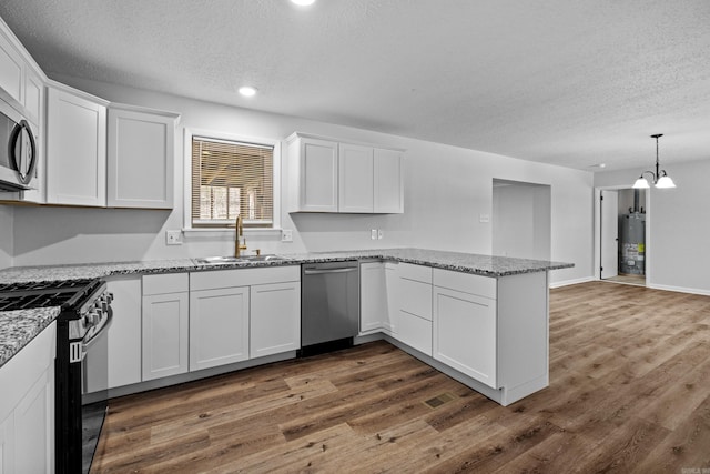 718 Coulter Rd, Sherwood, AR 72120 - kitchen with a sink, appliances with stainless steel finishes, gas water heater, a textured ceiling, and a peninsula
