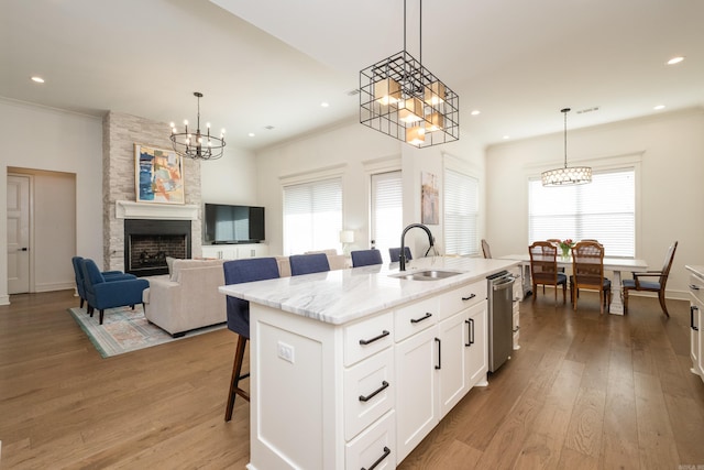 7021 Fields Dr, Alexander, AR 72019 - kitchen with a chandelier, a sink, a kitchen breakfast bar, an island with sink, and crown molding