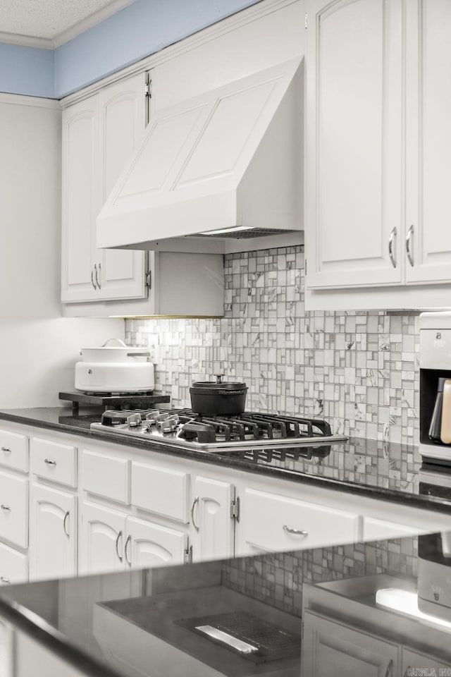 9 Leeward Ct, Maumelle, AR 72113 - kitchen featuring dark countertops, premium range hood, decorative backsplash, and white cabinetry