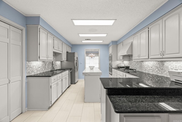 9 Leeward Ct, Maumelle, AR 72113 - kitchen featuring custom exhaust hood, stainless steel appliances, backsplash, a center island, and a textured ceiling