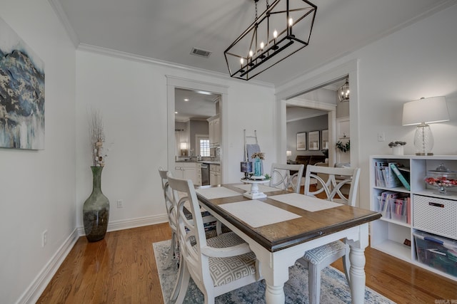 4715 Stockton Rd, Conway, AR 72034 - dining space with wood finished floors, crown molding, a chandelier, and baseboards