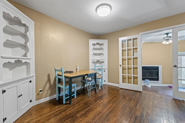 1217 Look St, Little Rock, AR 72204 - dining area with dark wood-type flooring, a ceiling fan, french doors, baseboards, and a glass covered fireplace