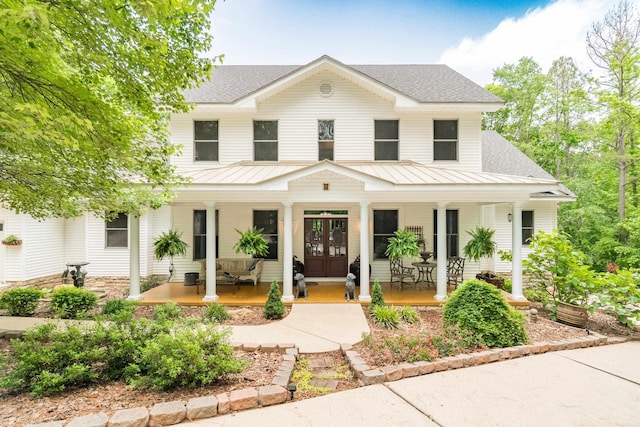 7 Galope Pl, Hot Springs Village, AR 71909 - modern farmhouse style home with covered porch, french doors, and a standing seam roof