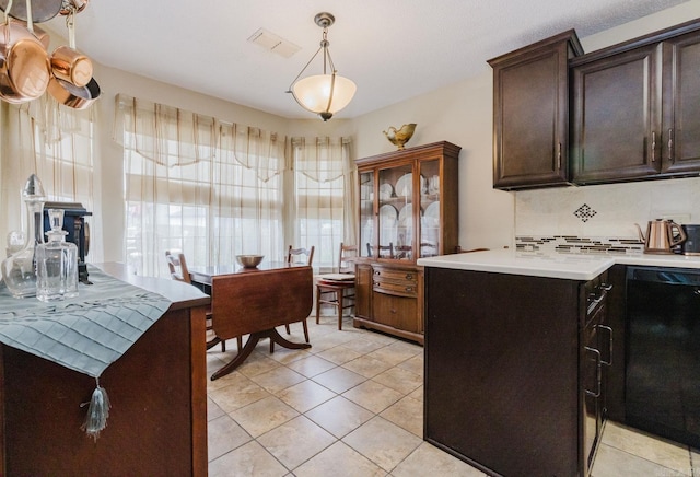 kitchen featuring dishwasher, light countertops, backsplash, and dark brown cabinetry