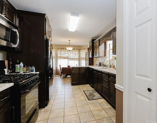 kitchen featuring black appliances, a sink, light countertops, light tile patterned floors, and a textured ceiling
