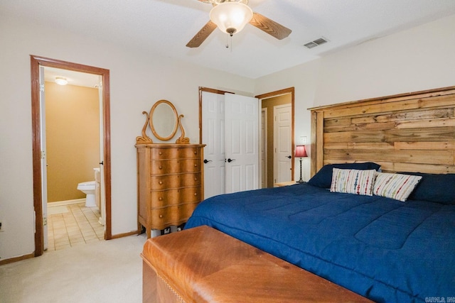 bedroom with light carpet, baseboards, ensuite bathroom, a closet, and a ceiling fan