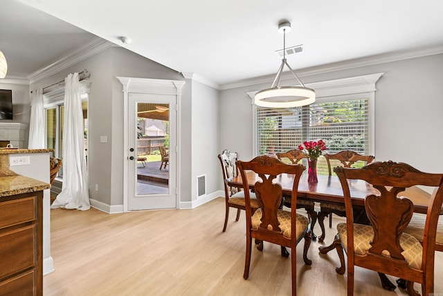 dining room with plenty of natural light, light wood finished floors, ornamental molding, and baseboards