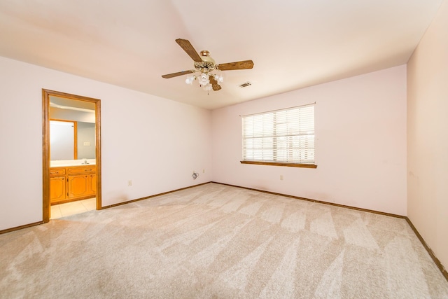 unfurnished room with light colored carpet, baseboards, and a ceiling fan