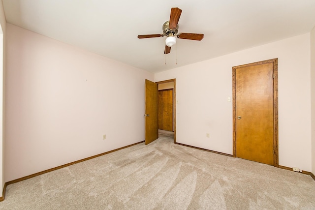 unfurnished bedroom featuring baseboards, light carpet, and a ceiling fan