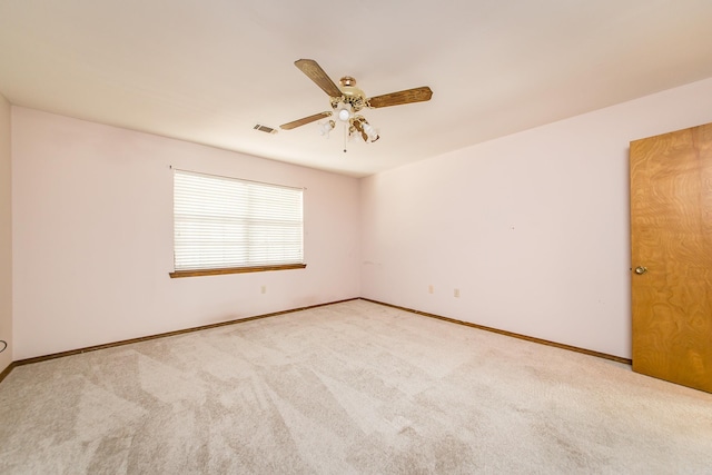 carpeted spare room featuring a ceiling fan and baseboards