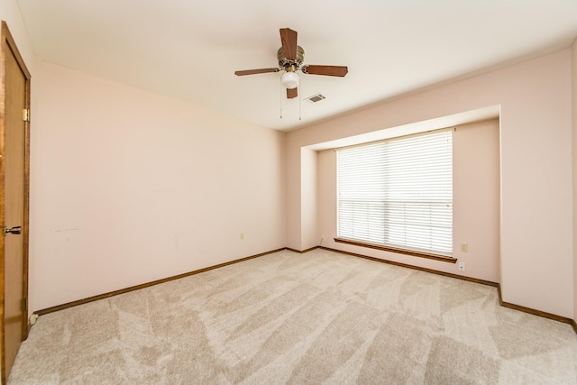 unfurnished room featuring light colored carpet, baseboards, and a ceiling fan