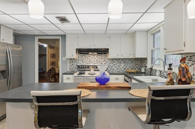 717 Choctaw Cir, Little Rock, AR 72205 - kitchen featuring range with two ovens, dark countertops, stainless steel refrigerator with ice dispenser, a paneled ceiling, and a sink