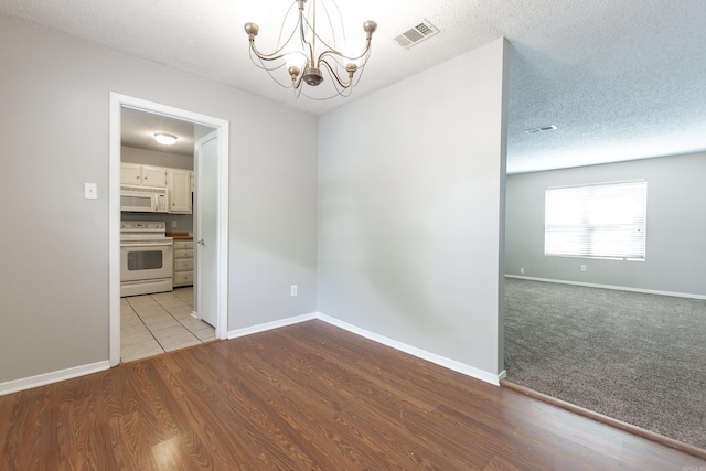 200 Pine Frst Unit F3, Maumelle, AR 72113 - unfurnished room featuring a chandelier, baseboards, wood finished floors, and a textured ceiling