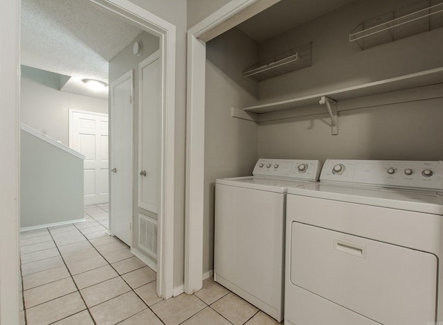 200 Pine Frst Unit F3, Maumelle, AR 72113 - washroom with light tile patterned floors, washing machine and clothes dryer, a textured ceiling, and baseboards