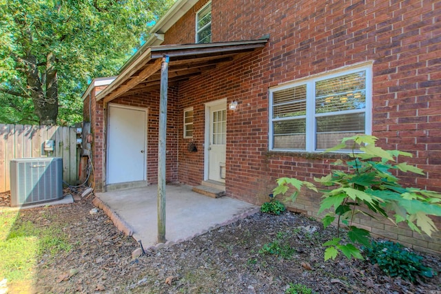 200 Pine Frst Unit F3, Maumelle, AR 72113 - view of exterior entry with central AC unit, fence, brick siding, and a patio