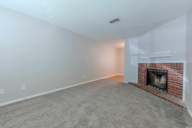200 Pine Frst Unit F3, Maumelle, AR 72113 - unfurnished living room featuring carpet flooring, a tiled fireplace, baseboards, and a textured ceiling