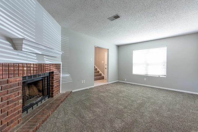 200 Pine Frst Unit F3, Maumelle, AR 72113 - unfurnished living room featuring a brick fireplace, a textured ceiling, carpet floors, baseboards, and stairs