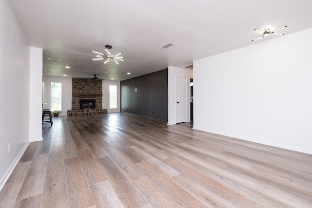 1117 Wild Turkey Ct, Little Rock, AR 72211 - unfurnished living room featuring wood finished floors, a stone fireplace, and baseboards