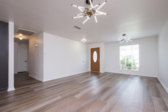 1117 Wild Turkey Ct, Little Rock, AR 72211 - unfurnished living room with wood finished floors, a chandelier, and baseboards