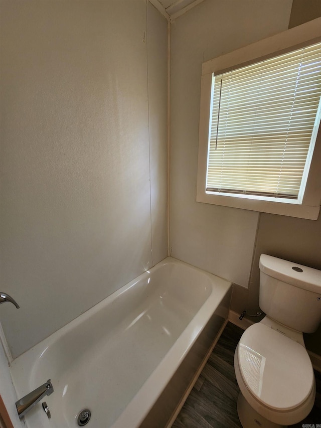 3716 Marion St, North Little Rock, AR 72118 - bathroom with toilet, a bathtub, wood finished floors, and baseboards