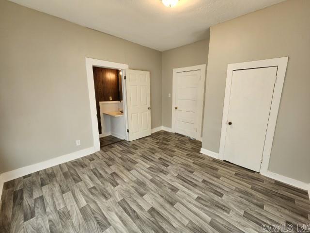 3716 Marion St, North Little Rock, AR 72118 - unfurnished bedroom featuring wood finished floors, baseboards, and ensuite bathroom