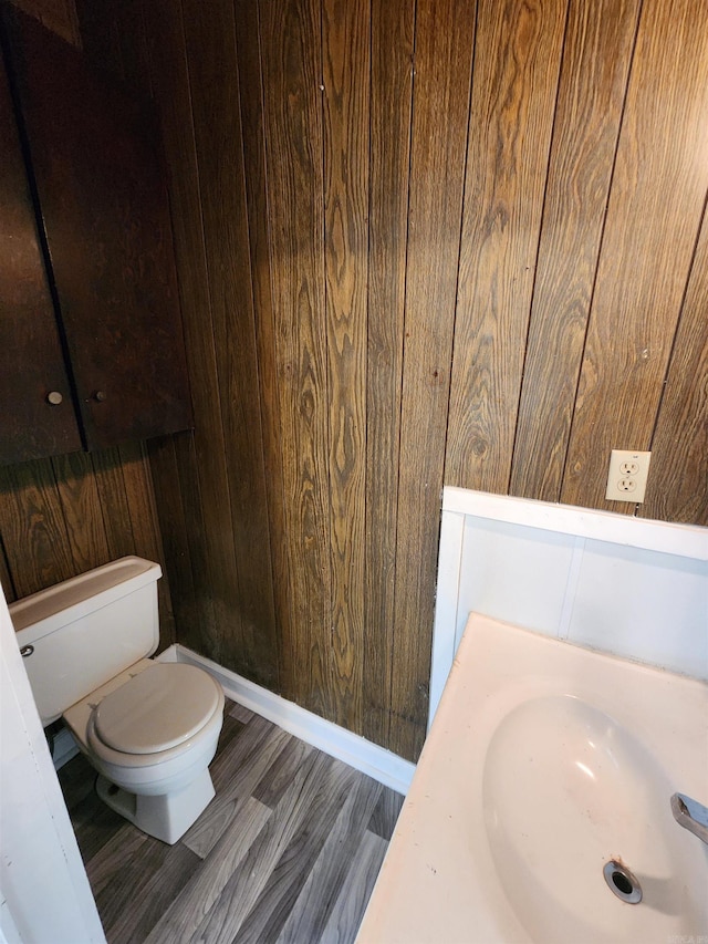 3716 Marion St, North Little Rock, AR 72118 - bathroom with wooden walls, toilet, a sink, and wood finished floors