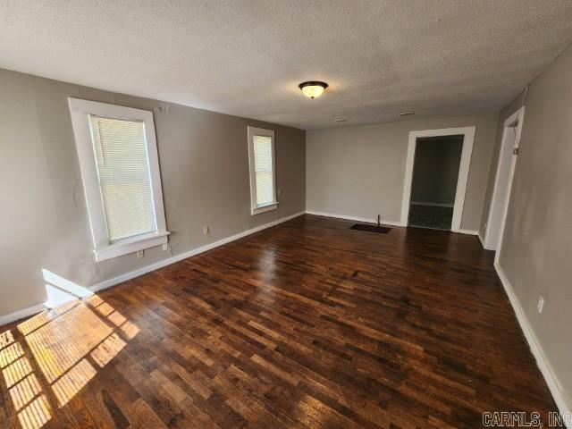 3716 Marion St, North Little Rock, AR 72118 - empty room with a textured ceiling, dark wood-style floors, and baseboards