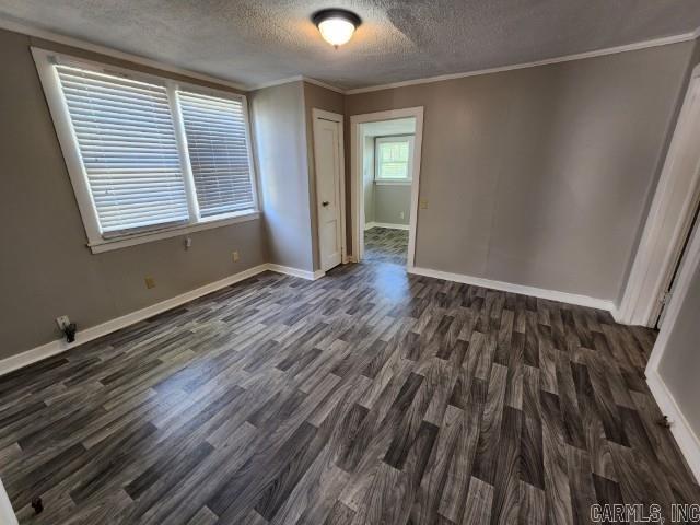 3716 Marion St, North Little Rock, AR 72118 - empty room featuring dark wood-style flooring, a textured ceiling, baseboards, and crown molding