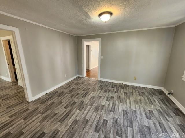 3716 Marion St, North Little Rock, AR 72118 - unfurnished room featuring a textured ceiling, dark wood-style floors, baseboards, and ornamental molding