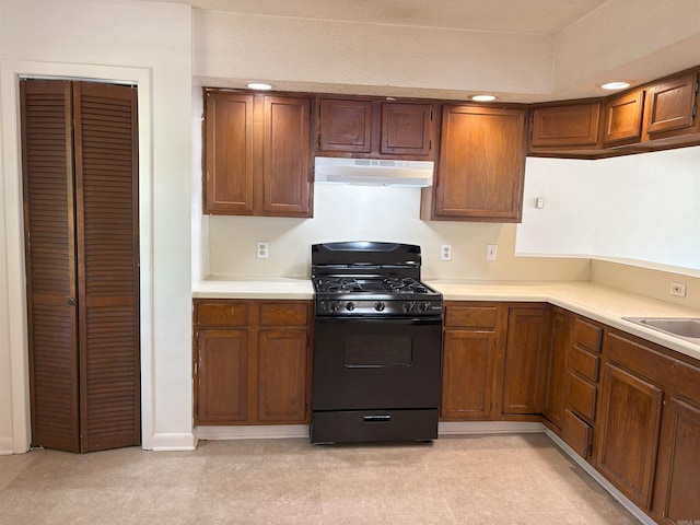 4900 Lochridge Rd, North Little Rock, AR 72116 - kitchen with gas stove, under cabinet range hood, light countertops, and brown cabinetry