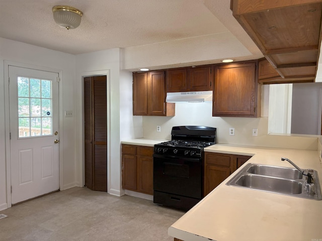4900 Lochridge Rd, North Little Rock, AR 72116 - kitchen featuring black gas range, under cabinet range hood, a sink, light countertops, and a textured ceiling