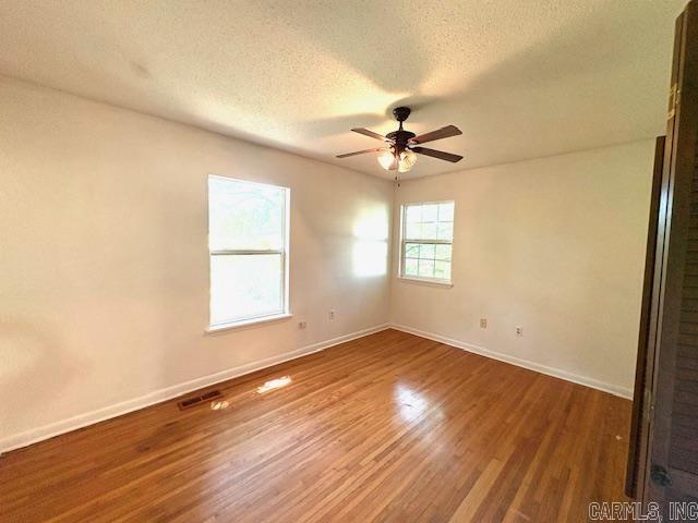 4900 Lochridge Rd, North Little Rock, AR 72116 - empty room featuring a textured ceiling, baseboards, a ceiling fan, and wood finished floors
