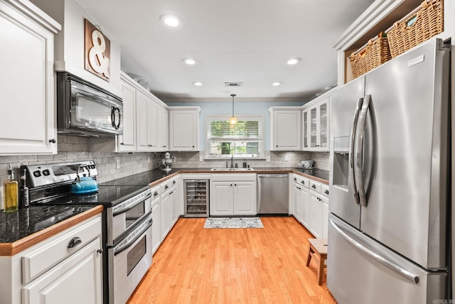 3016 Cleburne Pl, North Little Rock, AR 72116 - kitchen with appliances with stainless steel finishes, wine cooler, a sink, tile counters, and white cabinetry