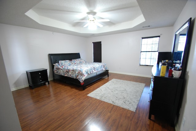 12601 Woodbury Dr, Little Rock, AR 72211 - bedroom with a tray ceiling, dark wood-style floors, and baseboards