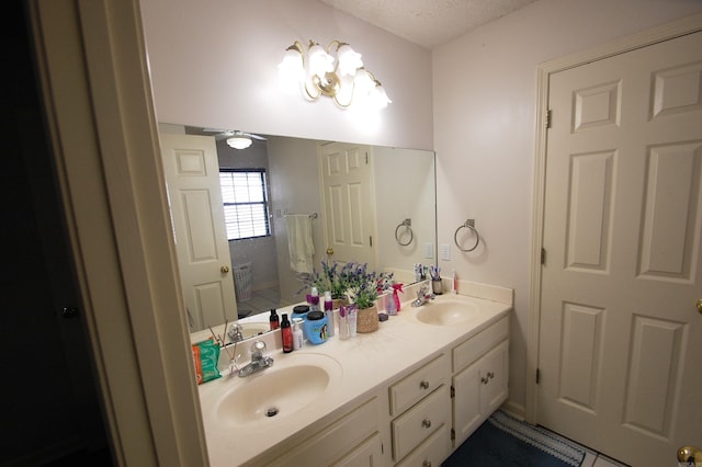 12601 Woodbury Dr, Little Rock, AR 72211 - bathroom featuring double vanity and a textured ceiling