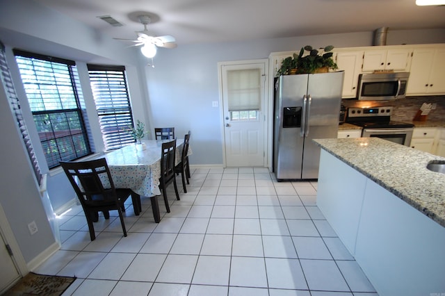 12601 Woodbury Dr, Little Rock, AR 72211 - kitchen featuring appliances with stainless steel finishes, a ceiling fan, backsplash, white cabinetry, and light stone countertops