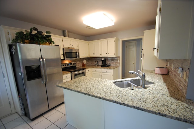 12601 Woodbury Dr, Little Rock, AR 72211 - kitchen with appliances with stainless steel finishes, a sink, a peninsula, and decorative backsplash