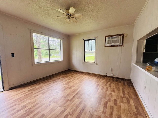 37 Maple St, Melbourne, AR 72556 - unfurnished room featuring a wall mounted air conditioner, light wood-style flooring, a ceiling fan, and a textured ceiling