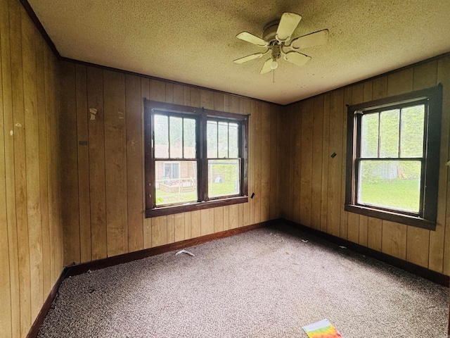 37 Maple St, Melbourne, AR 72556 - unfurnished room featuring a ceiling fan, carpet flooring, baseboards, wood walls, and a textured ceiling