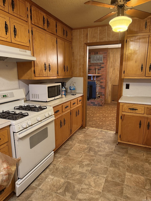 514 S Sawmill Rd, Searcy, AR 72143 - kitchen featuring white appliances, under cabinet range hood, a ceiling fan, wooden walls, and light countertops