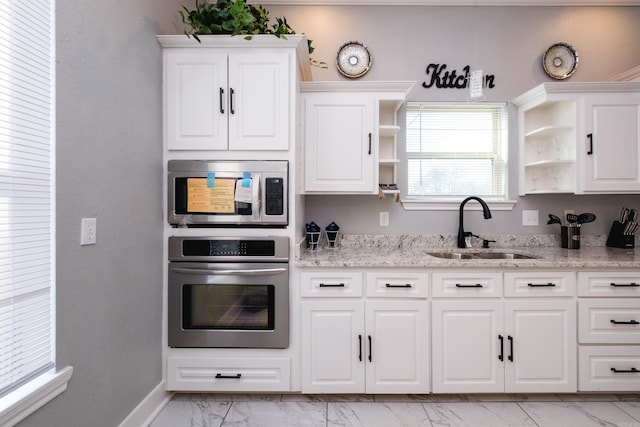 1608 S Cross St, Little Rock, AR 72206 - kitchen with stainless steel appliances, a sink, light marble finish floors, open shelves, and white cabinets