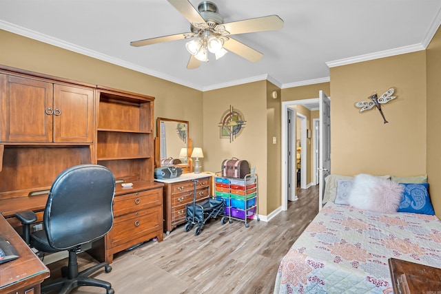 bedroom featuring light wood finished floors, an office area, baseboards, crown molding, and a ceiling fan