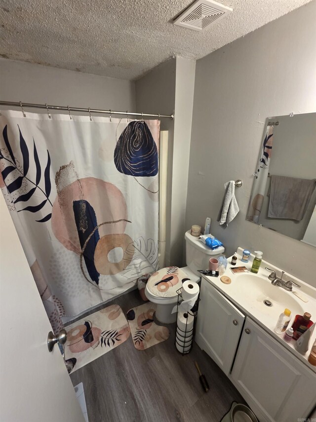 2113AND2115 Scotty Ct, Little Rock, AR 72204 - full bathroom featuring wood finished floors, toilet, a textured ceiling, vanity, and a shower with shower curtain