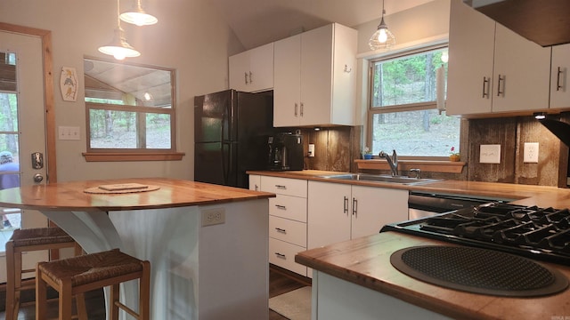 180 Herschel B Guinn Rd, Story, AR 71970 - kitchen with butcher block countertops, a sink, freestanding refrigerator, tasteful backsplash, and lofted ceiling