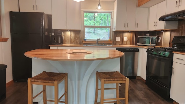 180 Herschel B Guinn Rd, Story, AR 71970 - kitchen with black appliances, under cabinet range hood, a sink, and dark wood finished floors