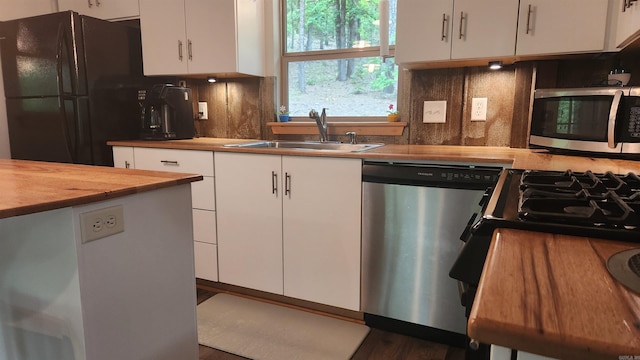 180 Herschel B Guinn Rd, Story, AR 71970 - kitchen featuring appliances with stainless steel finishes, white cabinetry, a sink, and tasteful backsplash